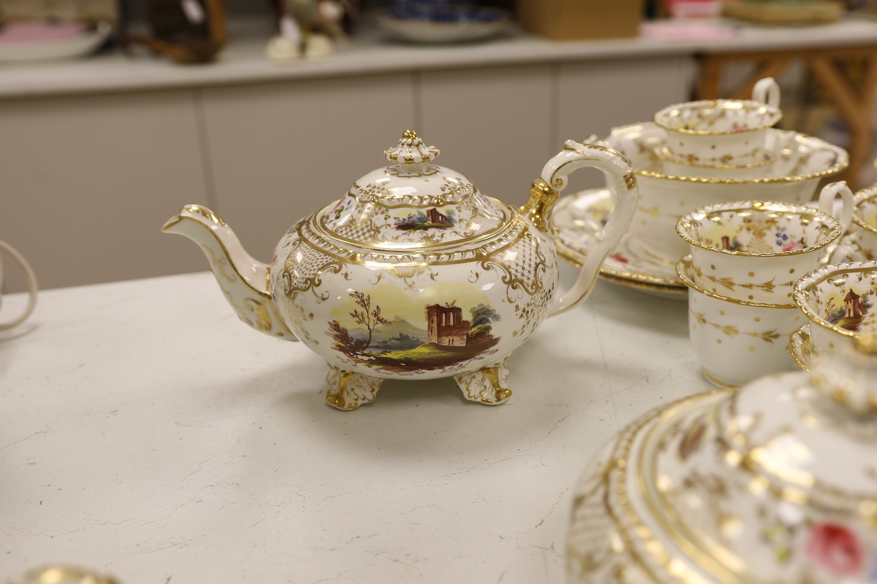 An early 19th century H & R Daniel landscape painted tea and coffee set, including twelve tea cups and saucers, twelve coffee cups, a teapot, a jug and a covered serving bowl, teapot 15cm high